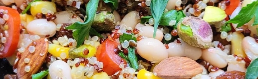 a colourful bowl of salad, nuts and grains
